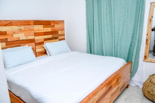 a bedroom with a bed with a wooden headboard at Familia@HeArt in Kakamega