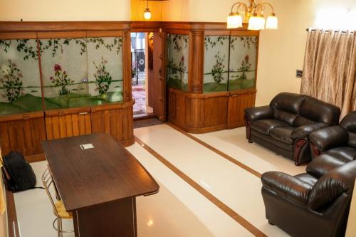 a waiting room with leather furniture and a table at Silver Homes Homestay in Alwaye