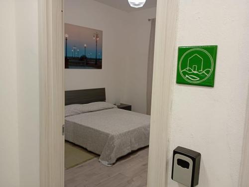 a bedroom with a bed and a green sign on the wall at CASAGRANDE - GUEST HOUSE in Livorno