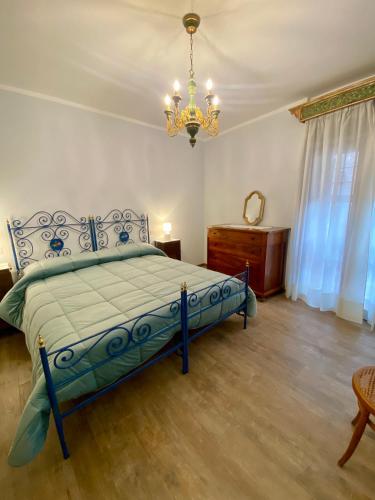 Un dormitorio con una cama azul y una lámpara de araña. en Casa Vacanze Il Borgo, en Gubbio