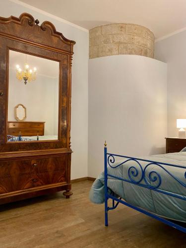 1 dormitorio con cama y espejo grande en Casa Vacanze Il Borgo, en Gubbio