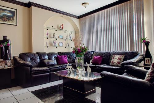 a living room with a leather couch and a table at Casa Palma 2 in La Paz