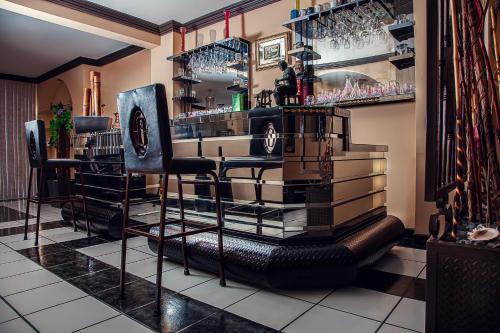 a bar with black bar stools and wine glasses at Casa Palma 2 in La Paz
