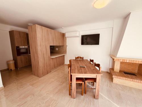 - une salle à manger avec une table et des chaises en bois dans l'établissement ALTAVILLAS Apartment 5 PORSCHA, à Kakí Vígla