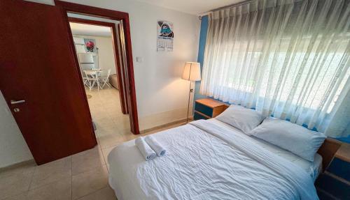 a bedroom with a large bed and a window at Salamandra Guest House מקלט פרטי in Nahariyya