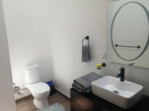 a bathroom with a white toilet and a sink at Bella Casa Blanca in El Castillo
