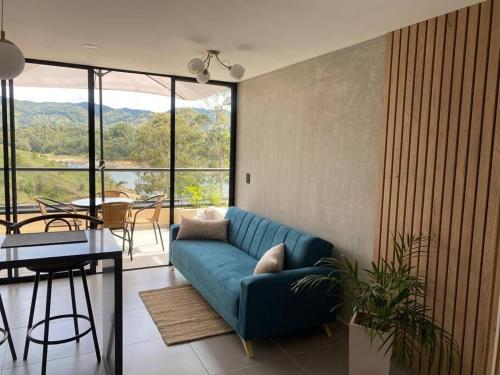 a living room with a blue couch and a table at Nuevo apto con acceso al embalse en Guatapé in Guatapé