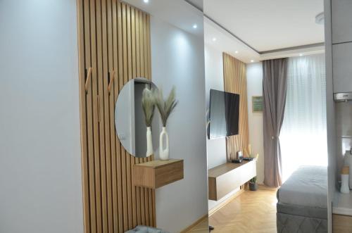 een kamer met een spiegel, een bed en een tv bij Apartman La Luna, Vrnjacka Banja in Vrnjačka Banja