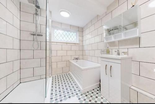 La salle de bains est pourvue d'une douche, de toilettes et d'un lavabo. dans l'établissement Newly renovated 4BR in Kings Cross with Garden, à Londres