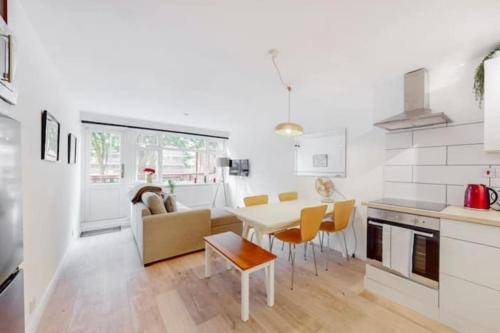 a kitchen and living room with a table and chairs at Modern 4BR Kings Cross - Patio & Balcony in London