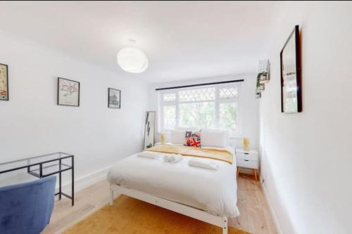 a white bedroom with a bed and a window at Modern 4BR Kings Cross - Patio & Balcony in London