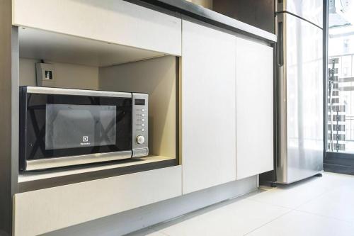 a microwave oven in a wall in a kitchen at Best Pool with 360 View of Pattaya & Best Location in Pattaya Central