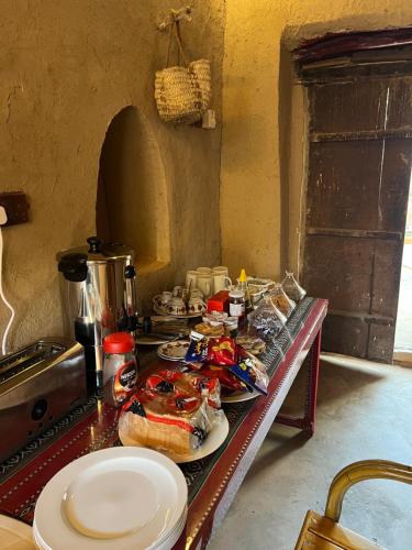 a table with plates of food on it in a kitchen at Mall Aldakhil House in Al Ḩamrāʼ