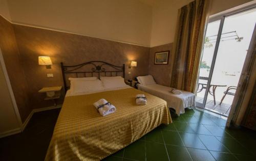 a bedroom with a bed with two towels on it at Hotel Scapolatiello in Cava deʼ Tirreni