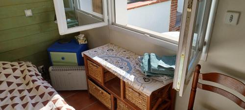 um pequeno quarto com uma cama e uma janela em L'Escale em Blagnac