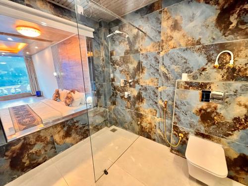 y baño con ducha con cabina de ducha de cristal. en Rockland Cottage, Manali - Centrally Heated & Air Cooled Premium Rooms en Manāli