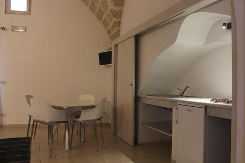 a kitchen with a table and chairs and a sink at Corte Taddeo B&B in Galatina