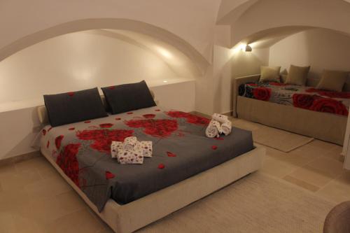a bedroom with a large bed with red roses on it at Corte Taddeo B&B in Galatina