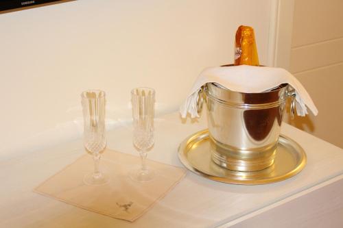uma garrafa de champanhe num balde com duas taças de vinho em Corte Taddeo B&B em Galatina