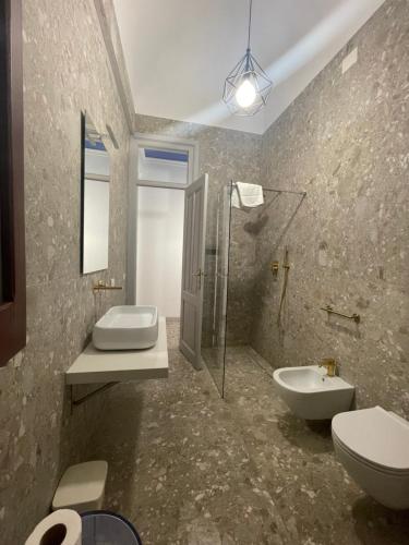 a bathroom with two sinks and a toilet and a shower at La Mattanza in Trapani