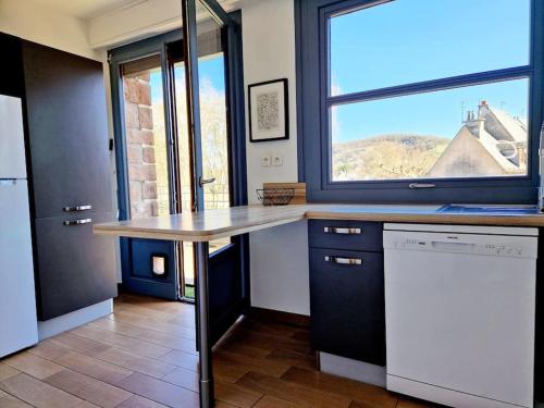 une cuisine avec un comptoir et une grande fenêtre dans l'établissement Haut Foirail, Balcon Centre-Ville, à Espalion