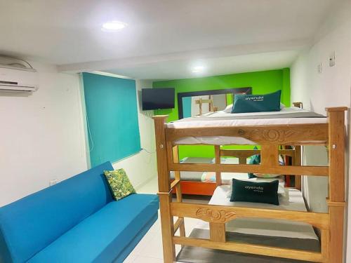 Pokój z łóżkiem piętrowym i niebieską kanapą w obiekcie Aparta Hotel Bacano Historico w mieście Santa Marta