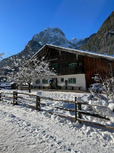 a house in the snow with a fence in front at Jagdhäusl in Ramsau