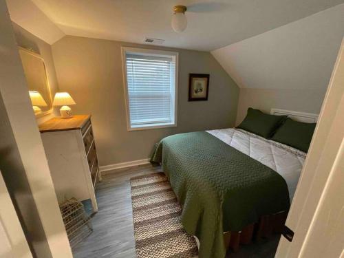 a bedroom with a green bed and a window at Hilltop Haven w/Creek&Waterfall Dntwn McCaysville in McCaysville