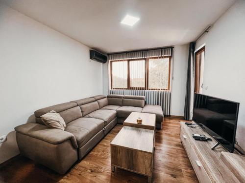 a living room with a couch and a tv at O3 Apartments in Tivat