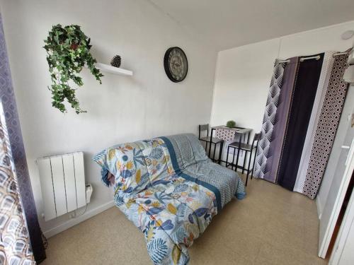 une chambre avec un lit et une horloge au mur dans l'établissement Studio - Marina 5 - 31 allée des Pignons - 4-1, à Saint-Jean-de-Monts