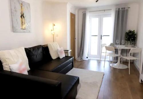 a living room with a black couch and a table at No 15 Modern Comfort in a Prime Southampton Location - Free Parking in Southampton