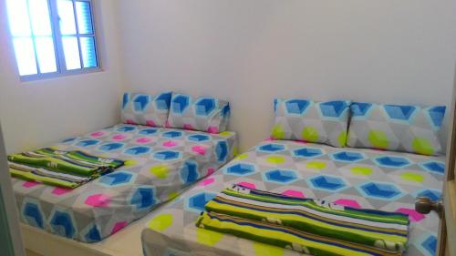 a bedroom with two twin beds and a window at Fastbook Sun Moon City Home 12Pax in Ayer Itam