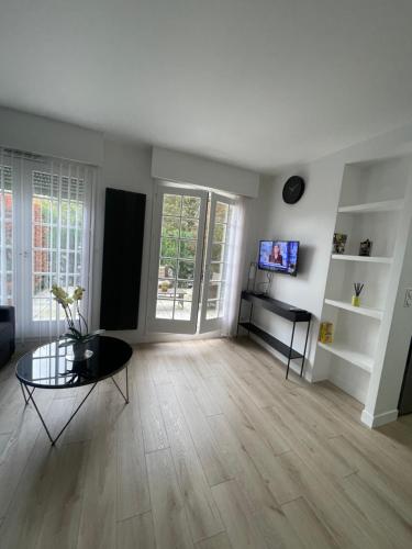 un salon vide avec une table et une télévision dans l'établissement Location Studio meublé Sceaux (proche Lakanal), à Sceaux