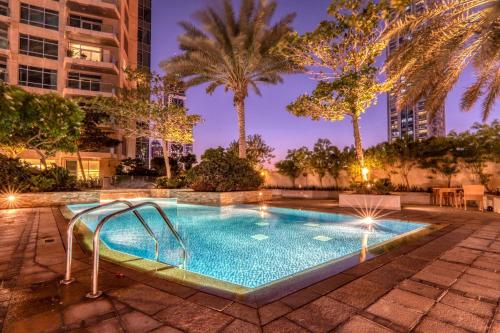 a swimming pool in a city at night at The Lofts - Luxurious space with Burj Khalifa View in Dubai