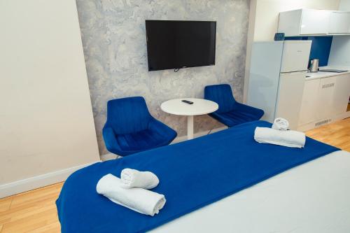 1 dormitorio con 1 cama azul y 2 sillas azules en Panorama Batumi Beach Resort en Batumi