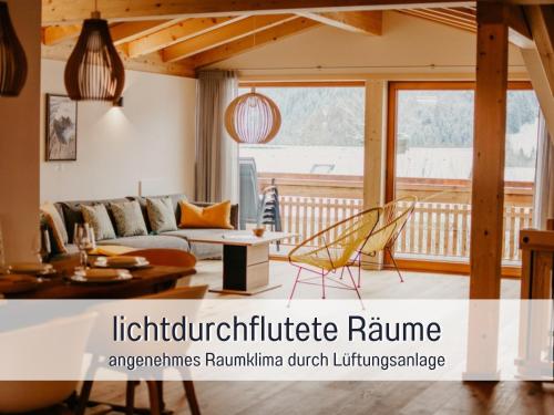 a living room with a couch and a table at Ferienwohnungen Scholl - private Sauna oder Infrarotkabine in Bad Hindelang