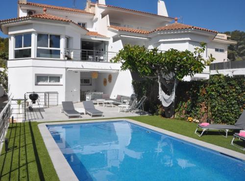 Villa con piscina frente a una casa en Miramar Sitges, en Sitges