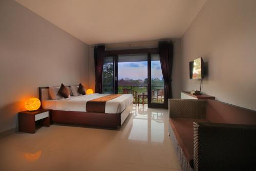 a bedroom with a bed and a large window at Srikandi Inn in Jimbaran