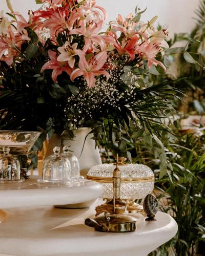 a table with a vase filled with pink flowers at Hotel Milam in Tulum