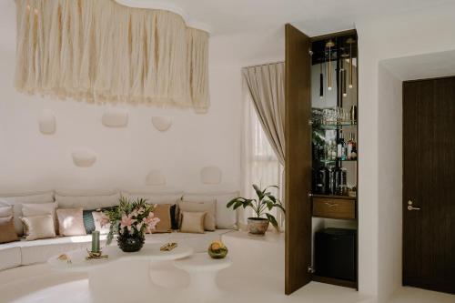 een witte woonkamer met een bank en een tafel bij Hotel Milam in Tulum