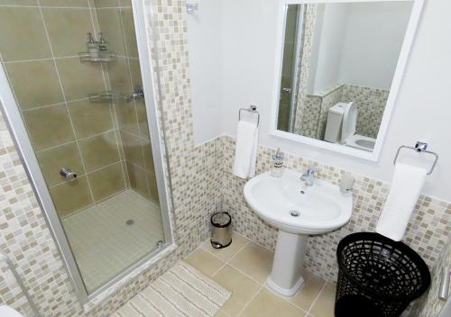 a bathroom with a shower and a sink at Cape Town Luxury Stays Knightsbridge Luxury Apartment Century City in Cape Town