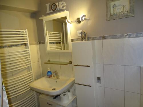 a white bathroom with a sink and a mirror at Ferienwohnung-Wacken in Wacken
