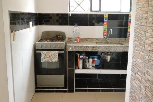 a small kitchen with a stove and a sink at Genesis Hospedaje Yopal in Yopal