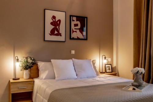 a bedroom with a bed with three pictures on the wall at Elichrysos Cozy Apartment in Heraklion