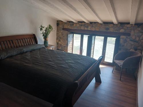 a bedroom with a bed and a stone wall at Cortijo rural los Cerezos pueblo Taberno in Albox