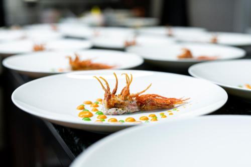 a row of white plates of food on a table at Il Porticciolo in Laveno-Mombello