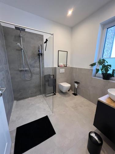 La salle de bains est pourvue d'une douche, de toilettes et d'un lavabo. dans l'établissement Heideglück, à Asendorf