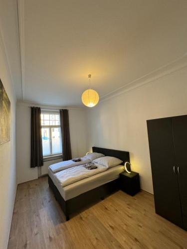 um quarto com uma cama, uma janela e um candeeiro em Wohnung gegenüber vom Theater em Gera