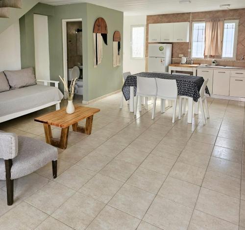 a kitchen and living room with a table and chairs at Alameda Apart in El Calafate