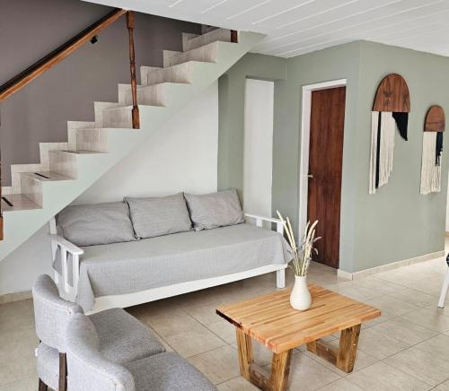 a living room with a couch and a staircase at Alameda Apart in El Calafate